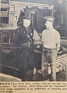 Police Chief and resident standing in front of a vehicle